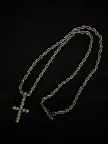 Cliente mostrando su Cadena Rope de 4mm plateada, a la que le ha añadido un dije de cruz con brillantes.