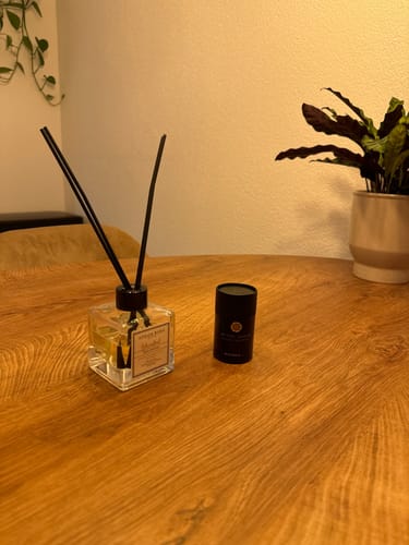 Recensents Istanbul geurstokjes met drie stokjes op een houten tafel, naast de verpakking.