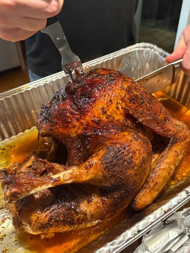 Customer showing a perfectly cooked, golden-brown turkey from the Turkey Brine Kit in a roasting pan.