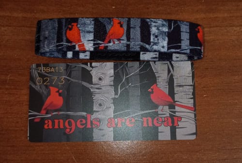 Customer's patterned Angels Are Near Bracelet with red cardinals, shown above its matching collector's card.