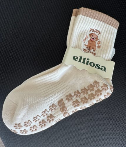 Customer's pair of Puppy Pilates socks, showing the cute puppy embroidery and non-slip paw print grips on the sole.