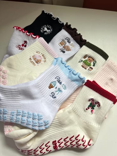 Reviewer's collection of cute Elliosa grip socks in various colors, featuring ruffled cuffs and embroidered details.