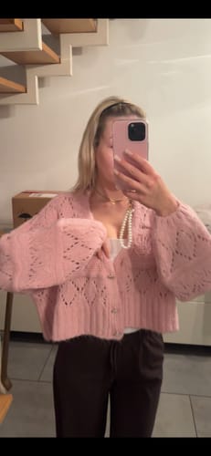 Kunde in einer Spiegelaufnahme, der den rosafarbenen, weichen Crystal Blush Cardigan trägt.