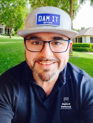 Reviewer smiling outdoors while wearing a gray cap featuring the blue and white Swap Patch.