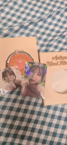 Reviewer's Red Velvet Wendy mirror and photocard set laid out on a checkered surface.