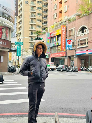 Customer wearing a black puffer jacket and pants, with the Jordan Basketball Shoes partially visible on a city street.