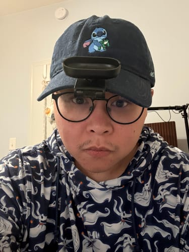 Reviewer wearing the navy blue Lilo & Stitch Dad Hat with a POV camera attached to the brim.