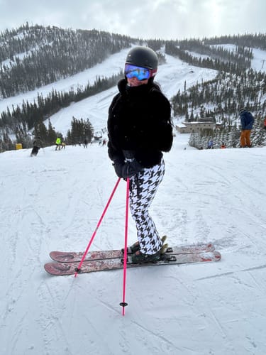 Reviewer skiing on a snowy mountain in the houndstooth slim-fit ski bibs.
