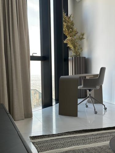 Customer's home office from the interior design service, featuring a sleek desk and chair by a large window.