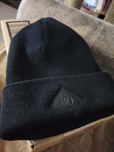 Customer's black 80eighty patch beanie resting on a box after unboxing.