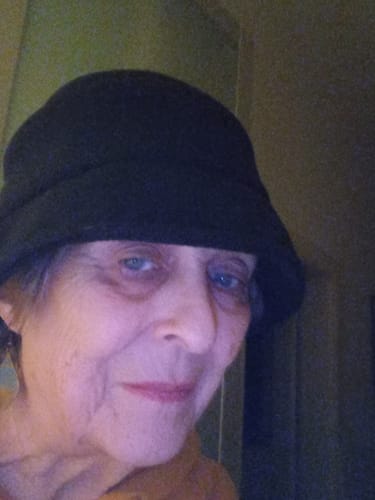 A close-up of a reviewer wearing the black, casual winter hat indoors.