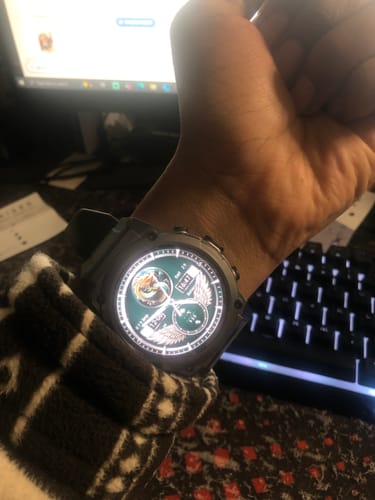 Close-up of a reviewer wearing the army green Gard Pro Ultra 3 watch with its face lit up.