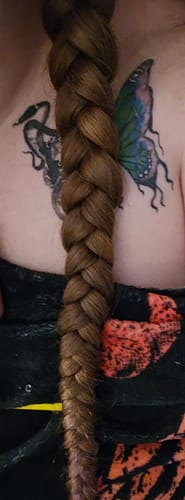 Close-up of a reviewer's long, thick braid after using the Hair and Body Oil.