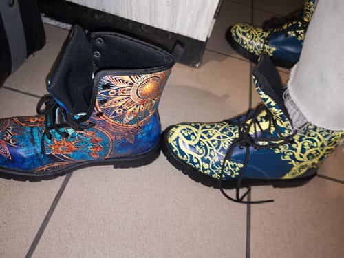 Cliente présentant ses Boots Yggdrasil, où chaque chaussure a un motif coloré et artistique différent.