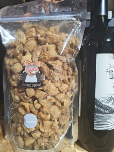 Customer's large, resealable bag of Original Big 'n' Mix pork scratchings sitting next to a bottle.