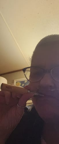 Close-up of a reviewer holding their light-wood FÜM device from the Journey Pack to their mouth.