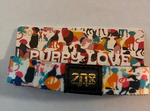 Reviewer's colorful Puppy Love Bracelet with its Zox gold foil band, shown with the matching collector's card.