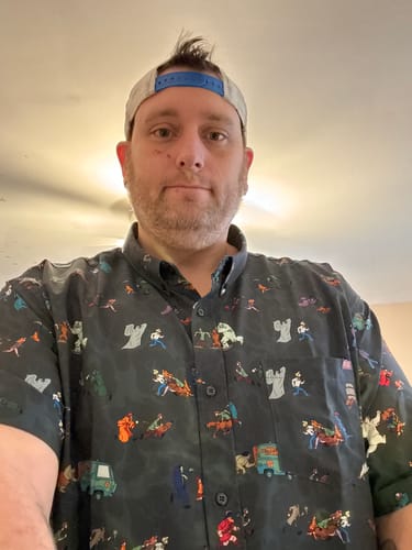 Customer wearing the patterned Scooby-Doo "Behind You!" – KUNUFLEX Short Sleeve Shirt indoors.