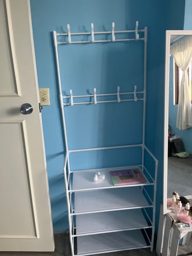 Un cliente muestra el clóset armable con zapatera Inkanto, de color blanco y ya ensamblado en una habitación.