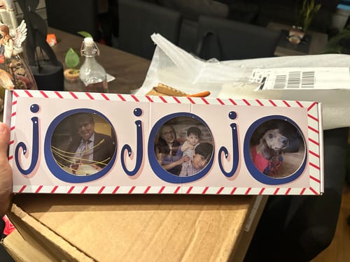 Cliente sosteniendo la caja de sus esferas personalizables, mostrando la nítida impresión de las fotos en el interior.