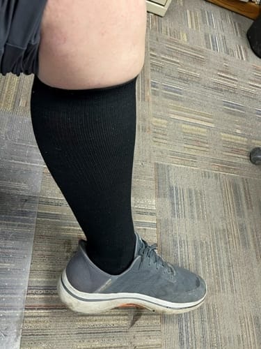 Customer's lower leg showing the comfortable fit of a black Performance Eucalyptus Compression Sock with a sneaker.
