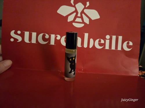 A customer's Heck Puppy roll-on bottle with a black animal label, shown in front of red packaging.