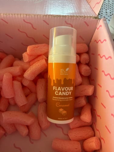 Cliente mostra il flacone di Flavour Candy al Caramello in una scatola di spedizione rosa con patatine di imballaggio.