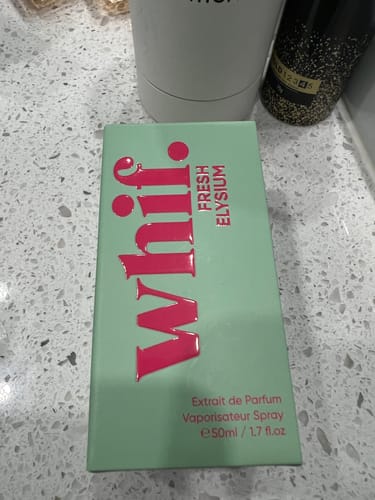 Reviewer's light green box for Fresh Elysium perfume with pink lettering, displayed on a speckled countertop.