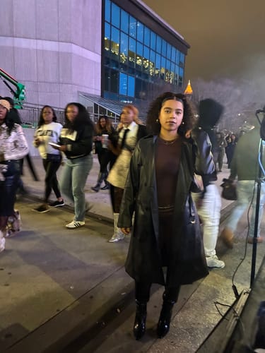 Reviewer standing outside at night wearing the Naked Closed Toe Legging with a long black coat and boots.