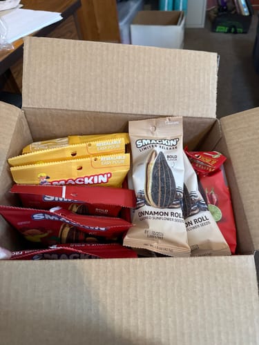 Customer's open box filled with various bags of SMACKIN' sunflower seeds.