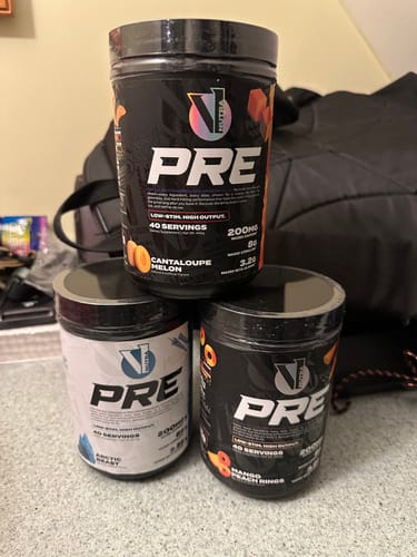 Reviewer's three tubs of V1 PRE WORKOUT in Cantaloupe Melon, Arctic Blast, and Mango Peach Rings flavors.