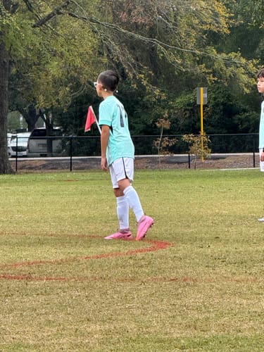 Customer on a soccer field wearing the Built-In Shin Pads under long white socks.