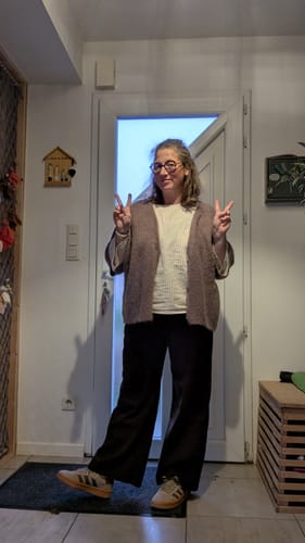 Cliente portant le pantalon Nestor chocolat, qui présente une coupe ample et décontractée.