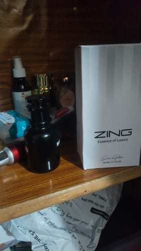 Customer's box for the Best selling Tester Pack on a wooden shelf next to a black perfume bottle.
