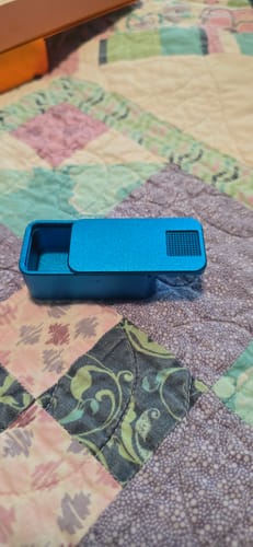 Reviewer's open blue Nano Case resting on a colorful quilt.
