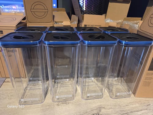 Klant toont acht heldere Bait Safe Containers met zwarte deksels, netjes op een rij gezet.