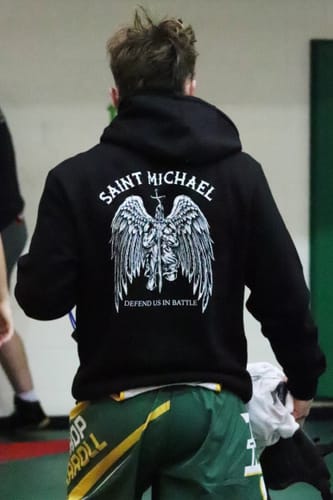 Customer wearing the Saint Michael Black Premium Hoodie, viewed from behind to show the large graphic on the back.
