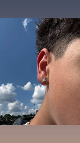 Close-up of a customer's ear, showing the square stud earring received as a free surprise item.