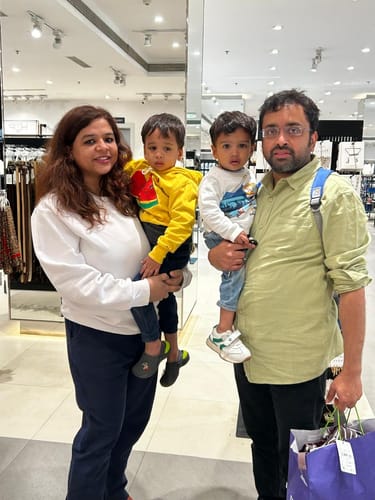 Reviewer wearing the white round neck sweatshirt while standing with family in a store.