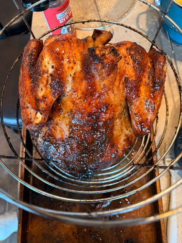 Customer's golden-brown turkey cooked with the Turkey Brine Kit, resting upright in an air fryer basket.