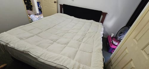 Customer's thick Luxury Mattress Topper fitted on a bed, showing the puffy quilted texture.