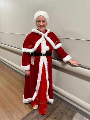 Reviewer smiling while wearing the complete red Christmas velvet hooded cloak dress outfit.