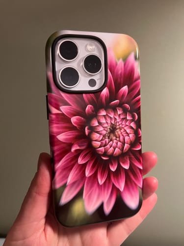 Customer holding a custom iPhone 16 Pro case with a detailed, vibrant pink dahlia print.
