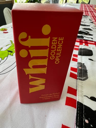 Customer's red whif. box for the Golden Opulence fragrance, standing on a table.