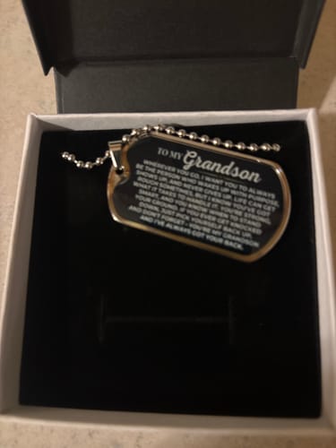 Reviewer's 'To My Grandson' Love Tag with its engraved message, shown resting inside its open gift box.