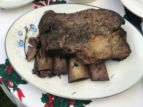 El Costillar completo de un cliente, cocido y servido en un plato blanco con flores azules.