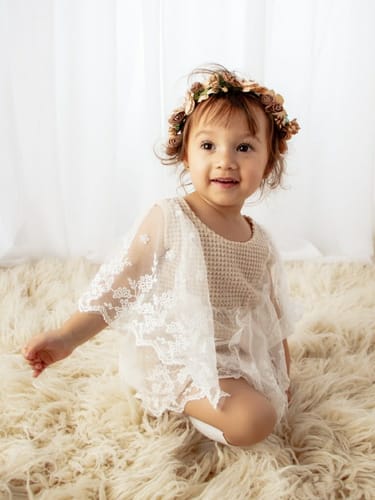 Customer's toddler models the rosy brown Rosie Flower Crown for a photoshoot.