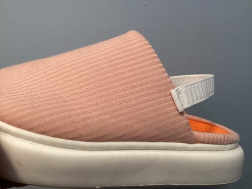 Reviewer's close-up of a modified pink Flummys slipper with a white elastic strap sewn onto the back.