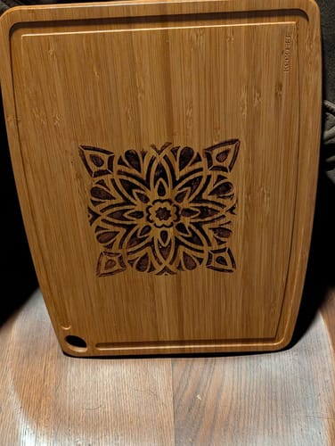 Customer's bamboo cutting board with a detailed mandala design burned into the center using Scorch Paint.