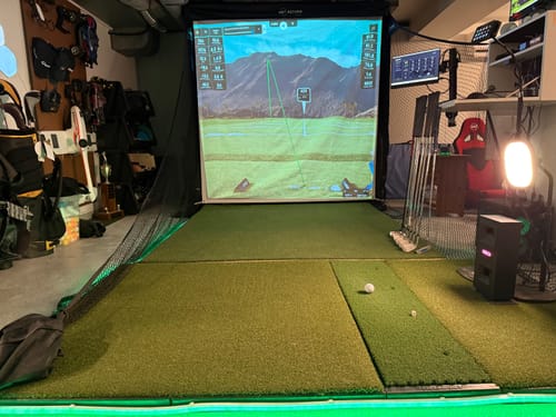 Net Return Home Series set up as a full home golf simulator with screen and projector